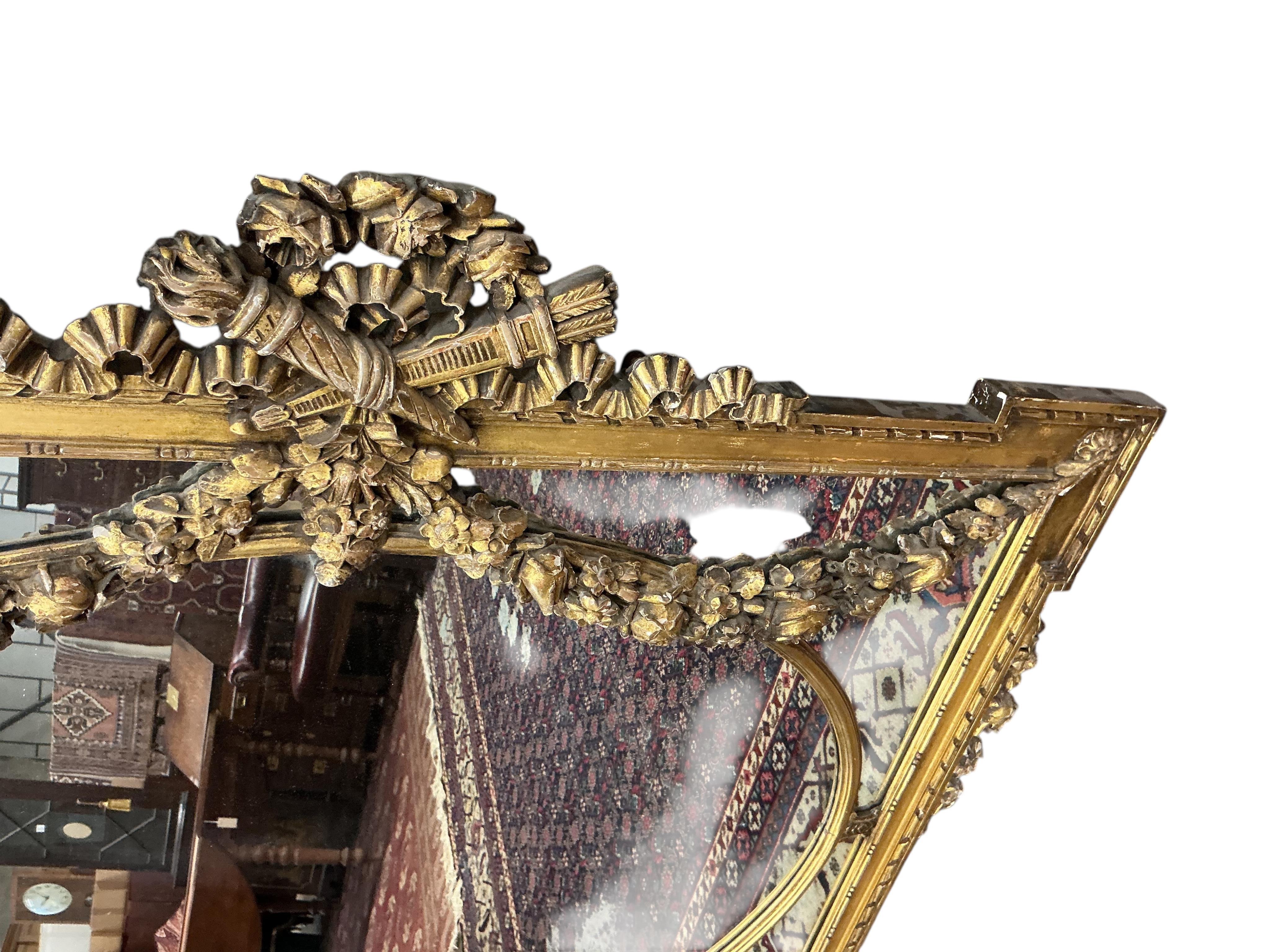 A Victorian style giltwood and composition overmantel mirror with cross torch and quiver crest, width 136cm, height 110cm
